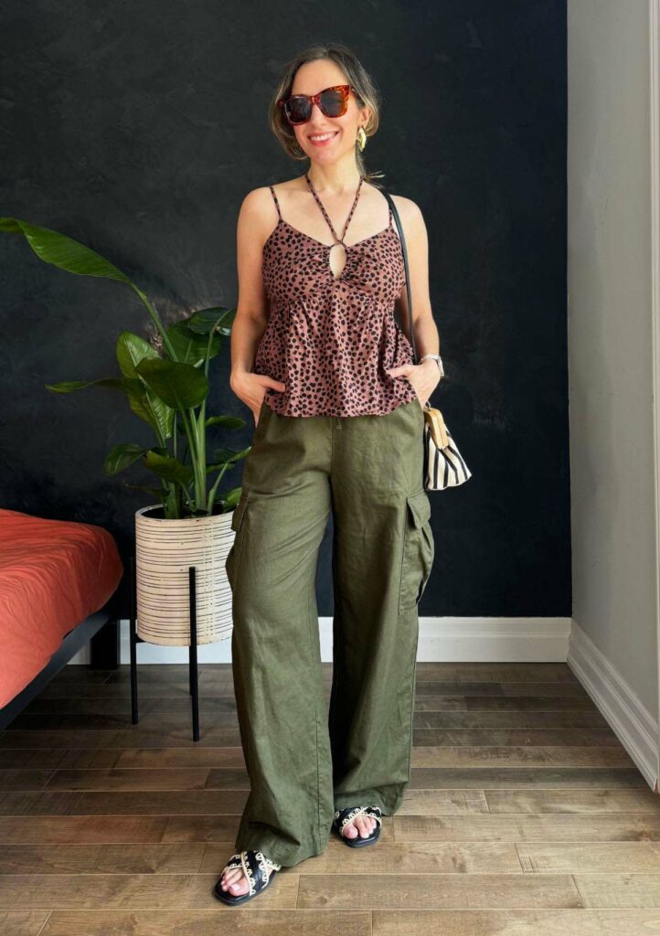 Woman posing wearing a linen camisole and wide leg linen pants for hot summer weather.