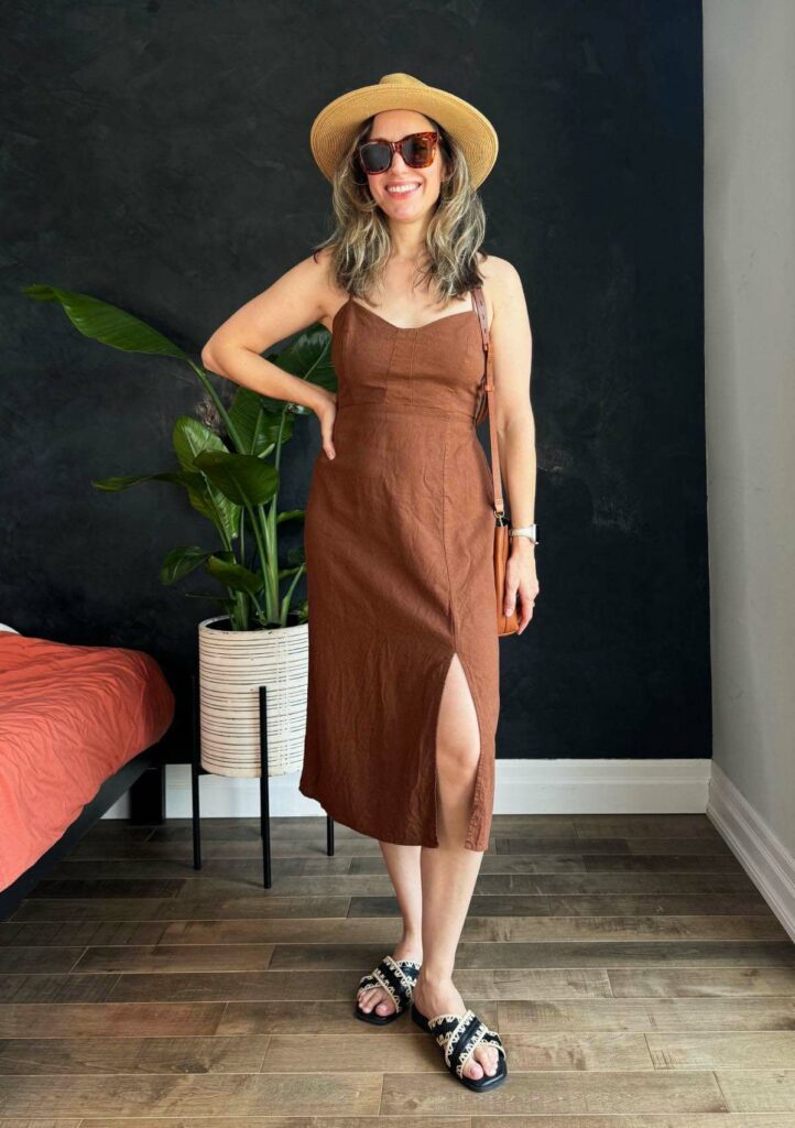 Woman posing wearing a brown linen dress.