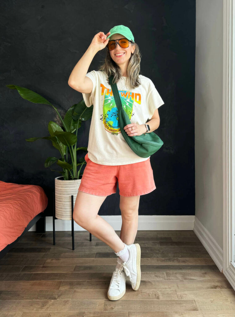 Woman posing wearing a graphic t-shirt outfit with sweatshorts.