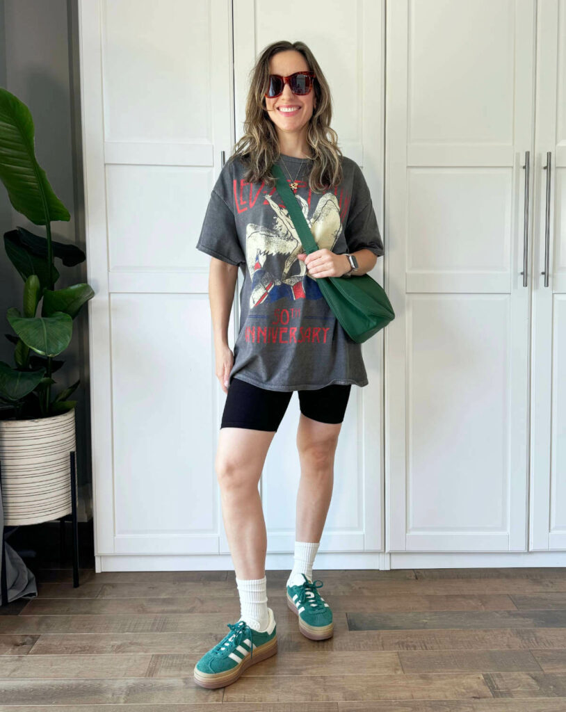 Woman posing wearing a graphic t-shirt outfit with black bike shorts.