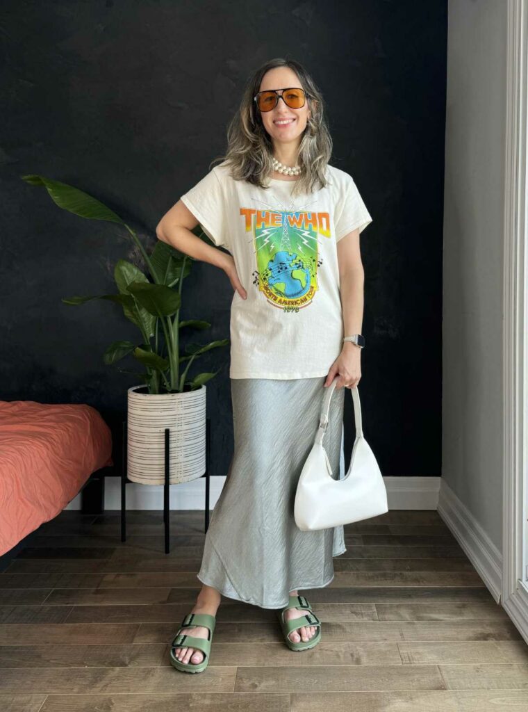 Woman posing wearing a graphic t-shirt outfit with a slip skirt.