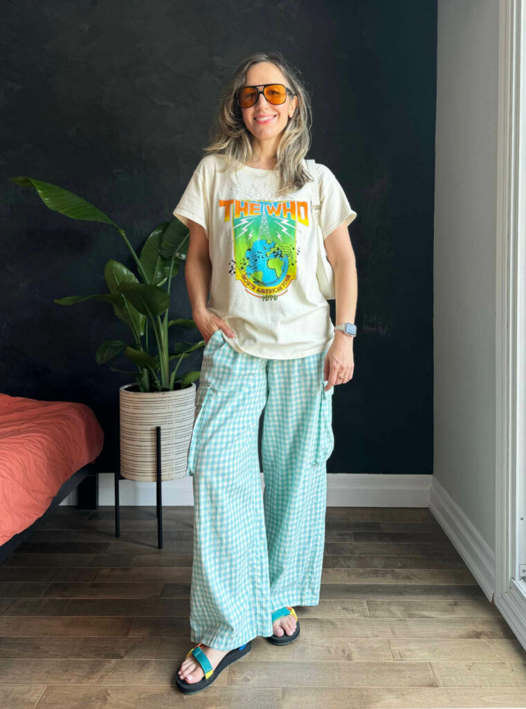 Woman posing wearing a graphic t-shirt outfit with gingham fleece PJ pants.