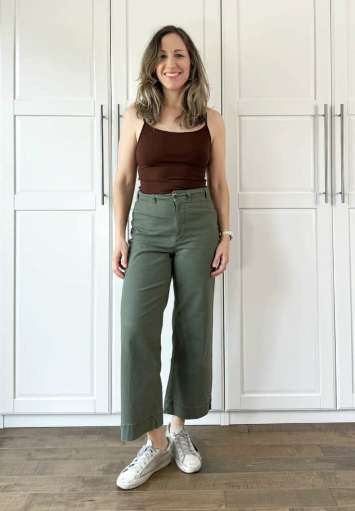 Woman posing wearing olive green pants with dark chocolate brown top.