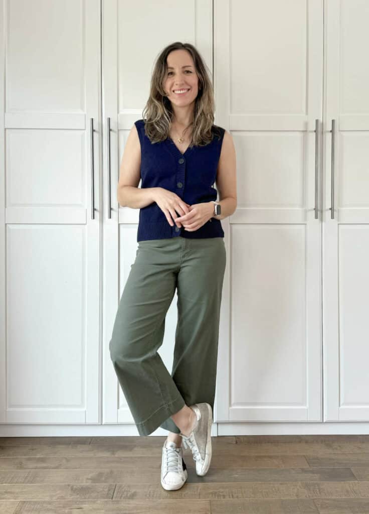 Woman posing wearing olive green pants with navy blue top.