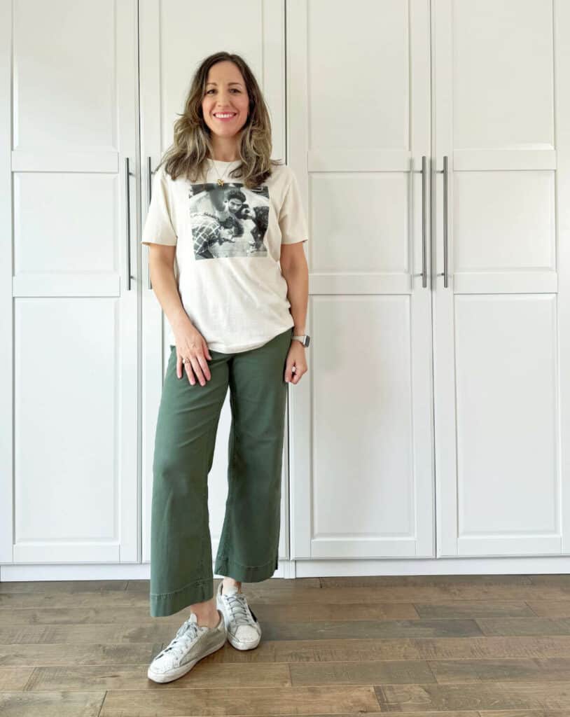 Woman posing wearing olive green pants with off-white top.