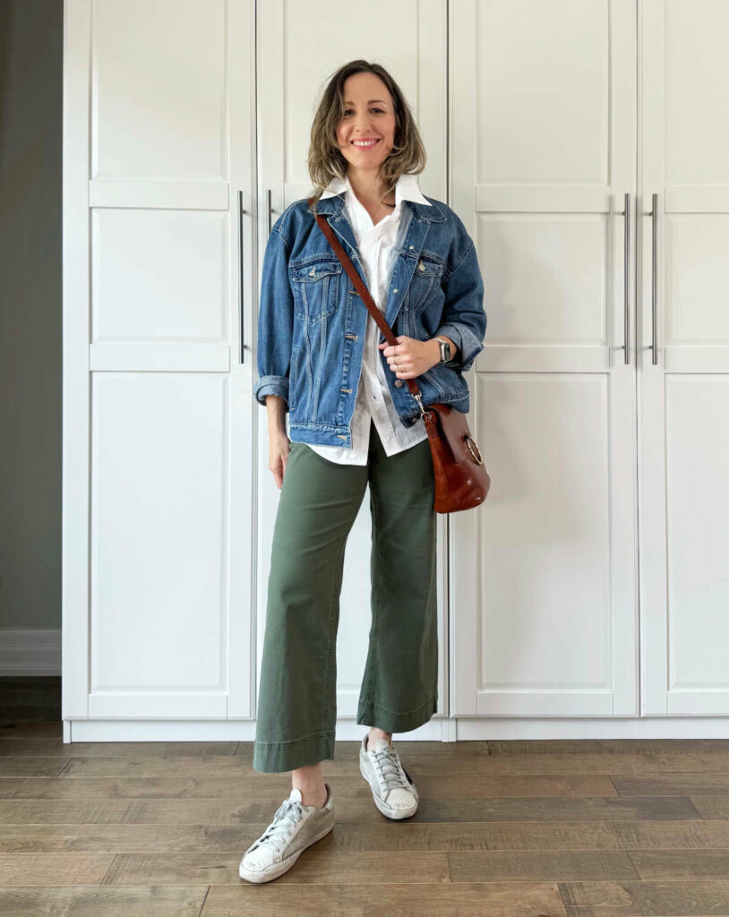 Woman posing wearing olive green pants for fall with casual with a denim jacket + white shirt.